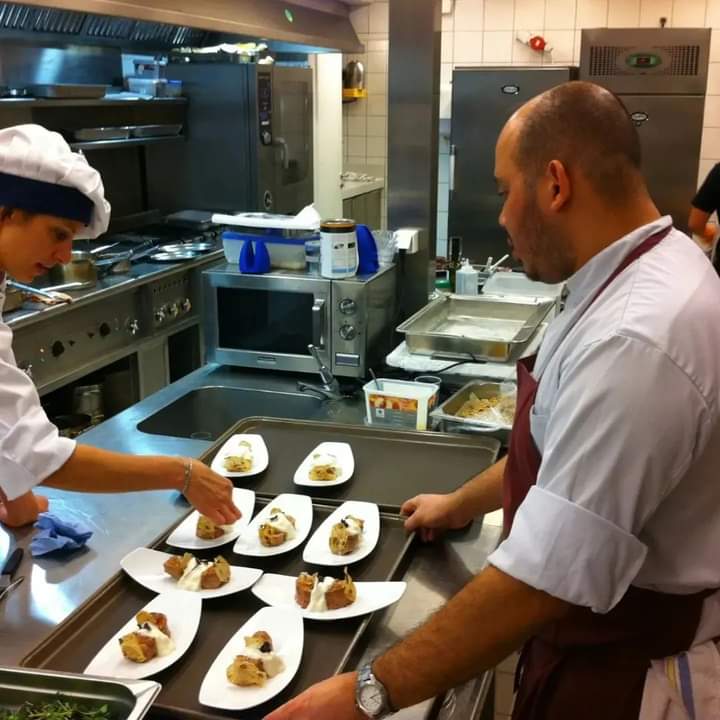Chefs plating dishes in a commercial kitchen